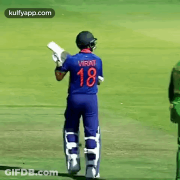 A Cricket Player Wearing A Blue Jersey With The Number 18 On It Is Standing On A Field Holding A Bat . GIF