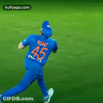 A Cricket Player Wearing A Blue Jersey With The Number 45 On The Back Is Running On A Field . GIF