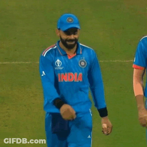 A Cricket Player Wearing A Blue Jersey With The Word India On It Is Standing On A Field . GIF