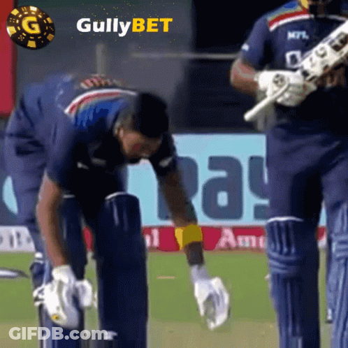 A Cricket Player Wearing A Blue Shirt With The Word Gullybet On The Bottom GIF