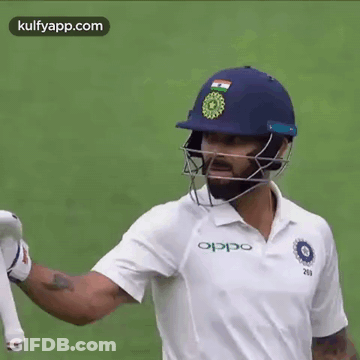 A Cricket Player Wearing A Helmet And A White Shirt . GIF