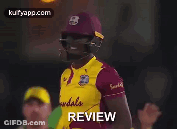 A Cricket Player Wearing A Helmet And Holding A Bat With The Word Review Written On It . GIF