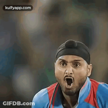 A Cricket Player Wearing A Turban And A Blue Shirt Is Standing On A Field . GIF