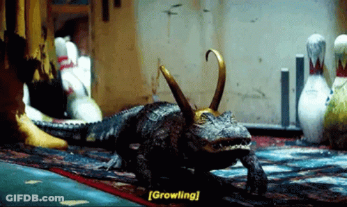 A Crocodile With A Crown On Its Head Is Walking On A Rug In A Bowling Alley . GIF