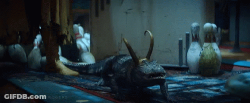 A Crocodile With Horns Is Standing In A Room With Bowling Pins GIF