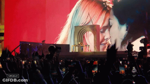 A Crowd At A Concert With A Sign That Says Cancella GIF