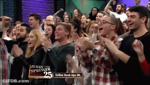 A Crowd Of People Applauding In Front Of Jerry Springer 25 GIF
