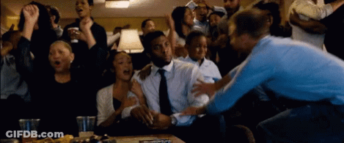 A Crowd Of People Are Gathered Around A Man In A Suit GIF