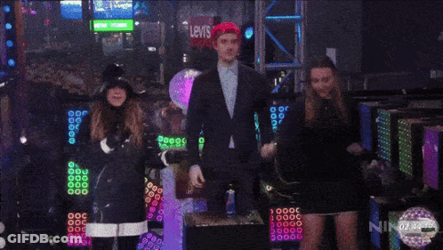 A Crowd Of People Are Gathered In A Dark Room With A Sign That Says Oh Call Me Yes ! GIF