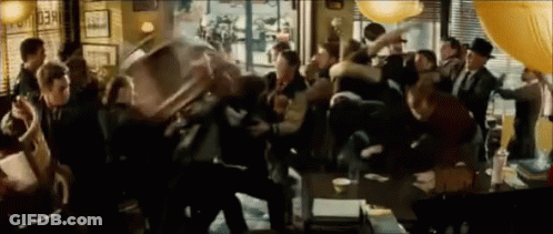 A Crowd Of People Are Gathered In A Room With A Sign That Says " Check Out " GIF