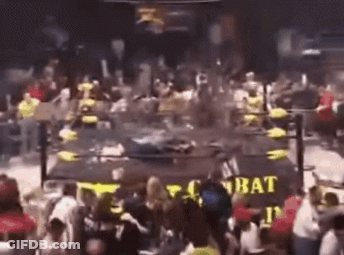 A Crowd Of People Are Gathered In Front Of A Sign That Says Combat . GIF