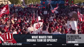 A Crowd Of People Are Gathered In Front Of A Sign That Says Indiana GIF