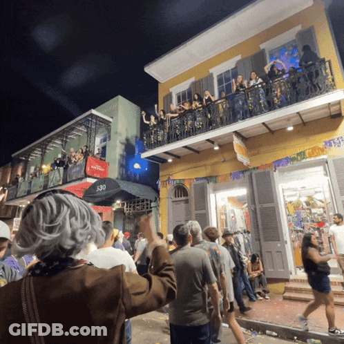 A Crowd Of People Are Gathered Outside A Building With The Number 530 On The Side GIF