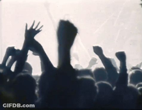 A Crowd Of People Are Raising Their Hands In The Air GIF