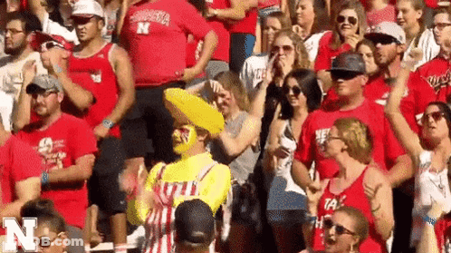 A Crowd Of People Are Sitting In A Stadium Wearing Red Shirts With The Letter N On Them GIF