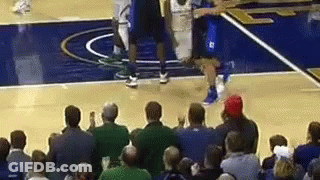 A Crowd Of People Are Watching A Basketball Game On A Basketball Court . GIF