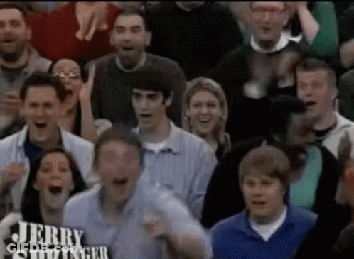 A Crowd Of People Are Watching A Game And One Of Them Is Holding A Sign That Says Jerry Siddinger GIF