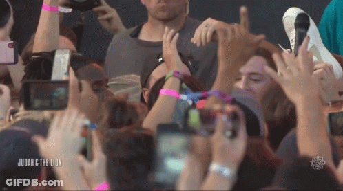 A Crowd Of People At A Concert With The Words Judah & The Lion Below Them GIF