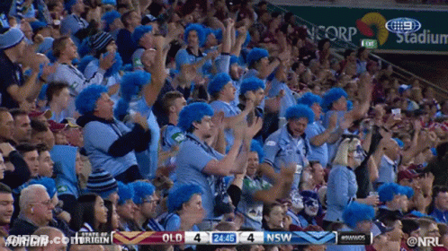 A Crowd Of People Cheering In A Stadium With A Scoreboard That Says #Origin GIF