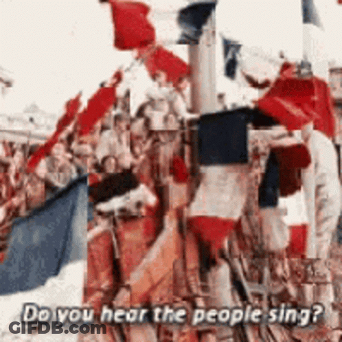 A Crowd Of People Holding Flags With The Words Do You Hear The People Sing Below Them GIF