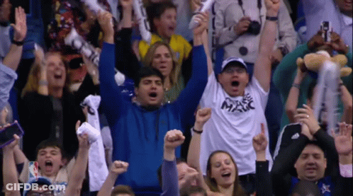 A Crowd Of People In A Stadium Including A Man Wearing A Shirt That Says Magic GIF