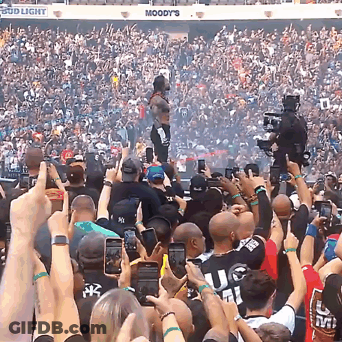 A Crowd Of People In A Stadium With A Bud Light Sign Above Them GIF