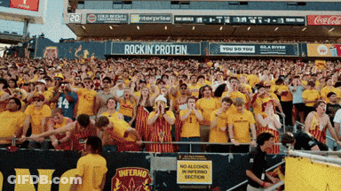A Crowd Of People In A Stadium With An Advertisement For Rockin Protein GIF