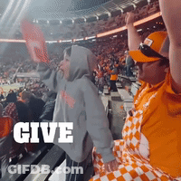 A Crowd Of People In A Stadium With The Word Give In White GIF