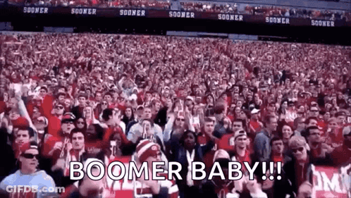 A Crowd Of People In A Stadium With The Words Boomer Baby ! GIF
