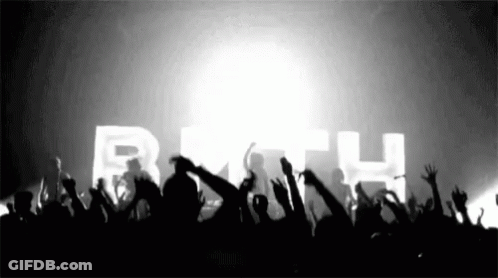 A Crowd Of People Raising Their Hands In The Air In Front Of A Sign That Says Beth GIF