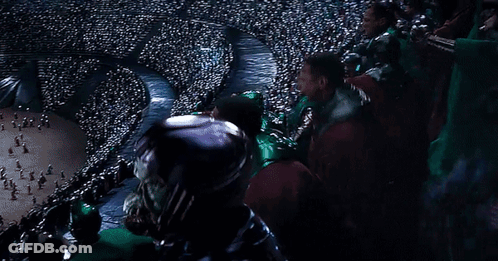 A Crowd Of People Sitting In A Stadium Watching A Game . GIF