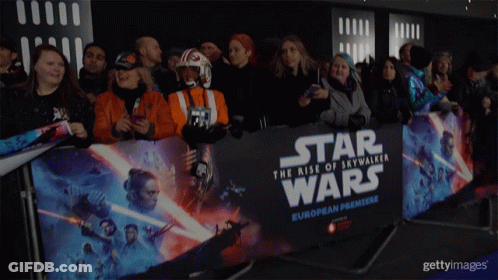 A Crowd Of People Standing In Front Of A Star Wars European Premiere Banner GIF