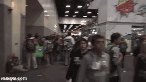 A Crowd Of People Walking In A Hallway With The Words Funny On The Bottom Right GIF