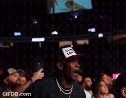 A Crowd Of People Watching A Boxing Match With One Man Wearing A Shirt That Says Kings GIF