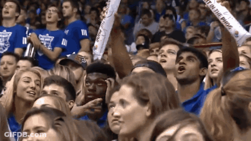 A Crowd Of People Watching A Game With A Banner That Says " Just On The Phog " GIF