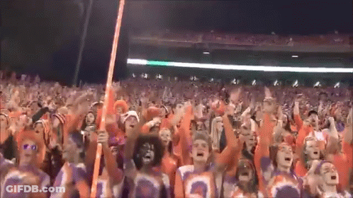 A Crowd Of People Wearing Orange And Purple Jerseys With The Number 3 On Them GIF
