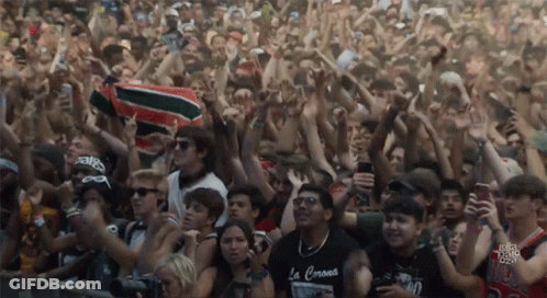 A Crowd Of People With One Wearing A Black Shirt That Says La Corona GIF