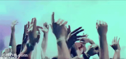 A Crowd Of People With Their Hands In The Air . GIF