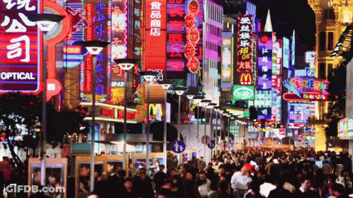 A Crowded City Street With A Sign That Says Optical GIF