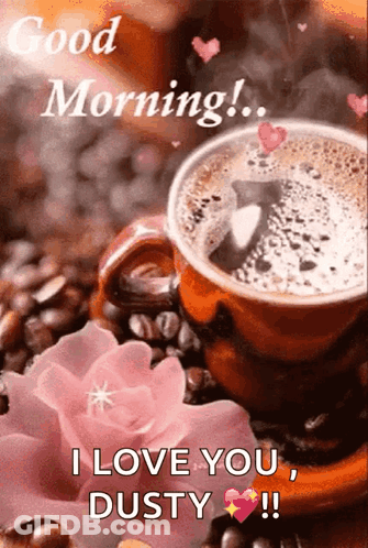 A Cup Of Coffee Is Sitting On Top Of Coffee Beans Next To A Pink Flower . GIF