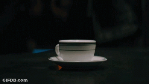 A Cup Of Coffee On A Saucer With A Black And White Stripe GIF