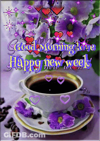A Cup Of Coffee Sits On A Saucer With Purple Flowers In The Background GIF