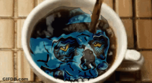 A Cup Of Coffee With A Blue Skull In It GIF