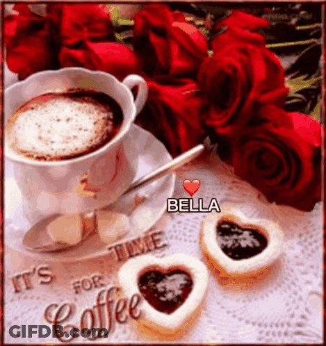 A Cup Of Coffee With A Heart Shaped Cookie Next To Roses GIF