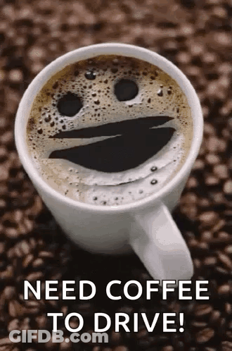 A Cup Of Coffee With A Smiley Face On It Is Sitting On A Pile Of Coffee Beans . GIF