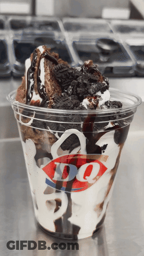 A Cup Of Dq Ice Cream With Oreos And Chocolate Sauce GIF