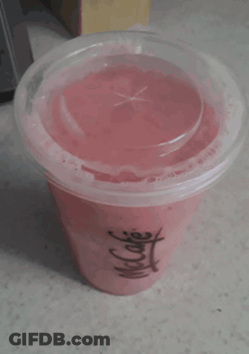 A Cup Of Pink Liquid With A Clear Lid And A Chinese Symbol On It GIF