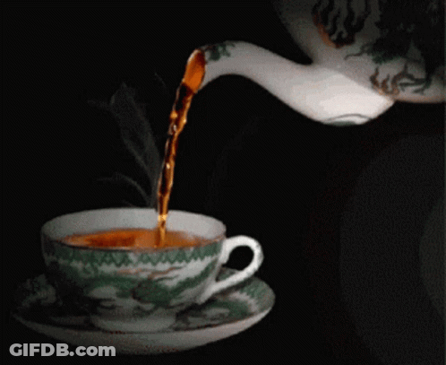A Cup Of Tea Is Being Poured From A Tea Kettle GIF