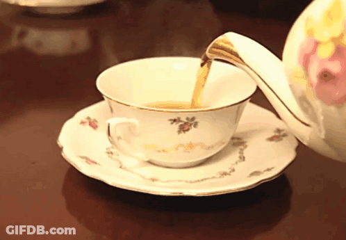 A Cup Of Tea Is Being Poured From A Teapot On A Saucer GIF