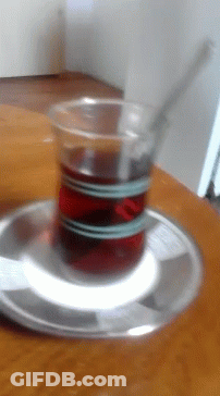 A Cup Of Tea Is On A Saucer On A Table GIF